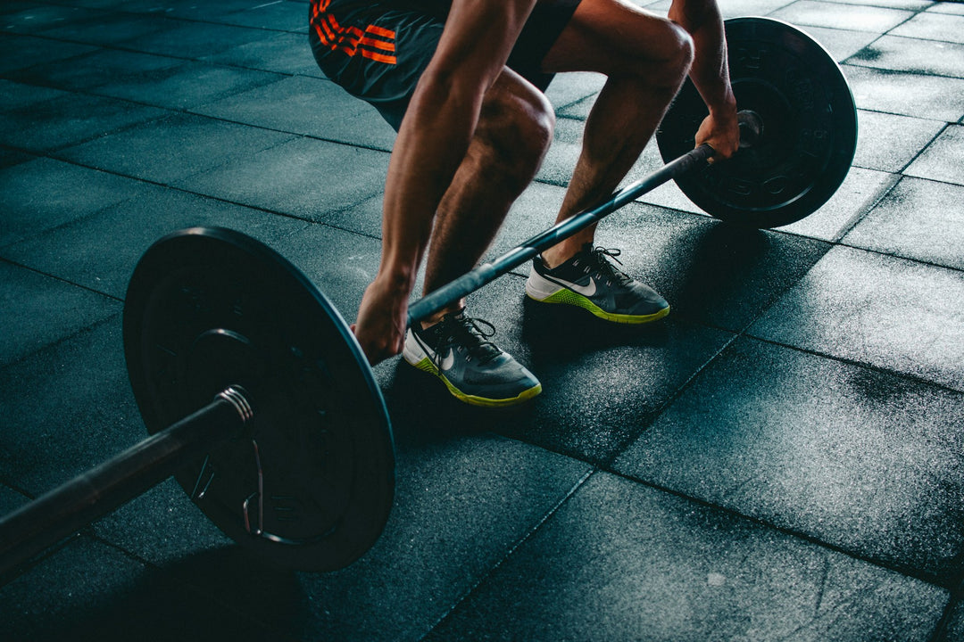 Dumbbells on a gym floor — strength training (Unsplash)